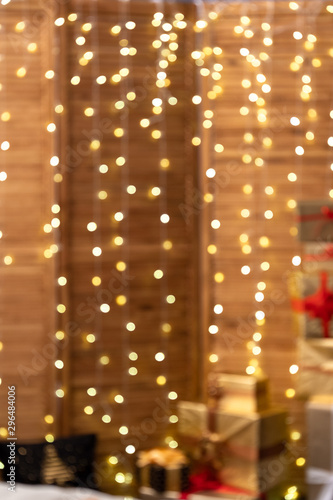 Christmas gifts in a large number of beautifully folded boxes Packed in Golden paper, decorated with bows of gold and chocolate ribbon. new year cozy background. lot of free space for text. defocusing
