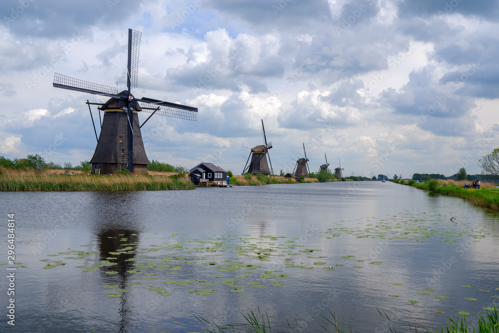 Kinderdijk, Netherlands - May, 2019. Tourist ride bicycle as she visit the windmills of Kinderdijk. The windmills of Kinderdijk are one of the best-known Dutch tourist sites.