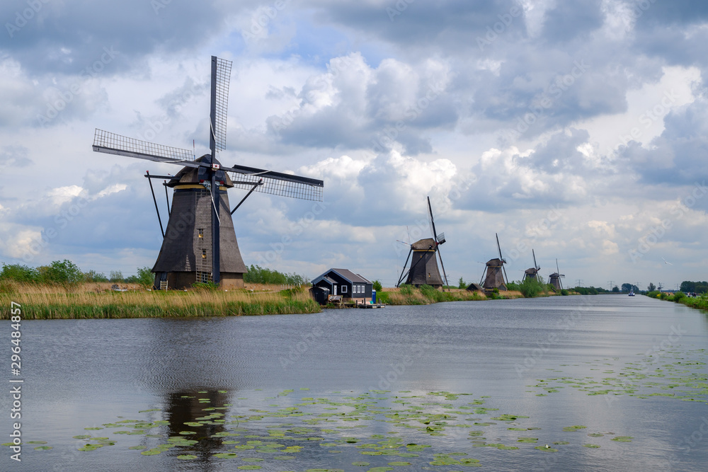 Kinderdijk, Netherlands - May, 2019. Tourist ride bicycle as she visit the windmills of Kinderdijk. The windmills of Kinderdijk are one of the best-known Dutch tourist sites.
