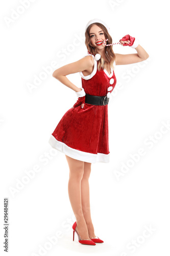 Beautiful woman dressed as Santa with candy cane on white background