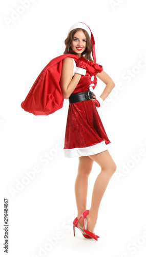 Beautiful woman dressed as Santa with bag on white background