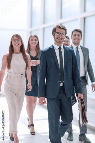 confident businessman and his business team passing through the office corridor