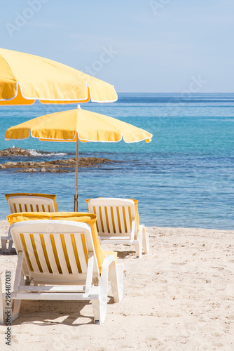 des chaises longues  des transats  des parasols sur une plage avec vue sur la mer pour les vacances