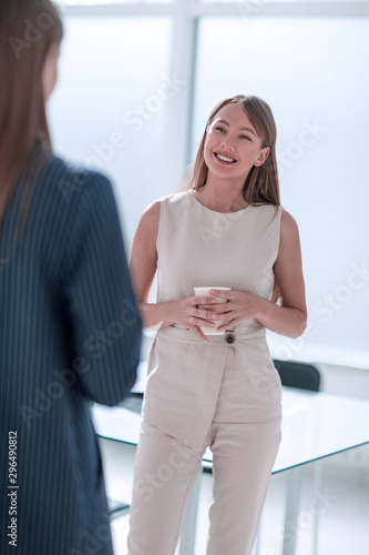 businesswoman with a glass of coffee discussing something with her colleague Free Download businesswoman with a glass of coffee discussing something with her colleague - GFXLoad