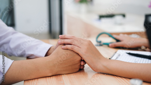 Doctor comforting patient at consulting room.