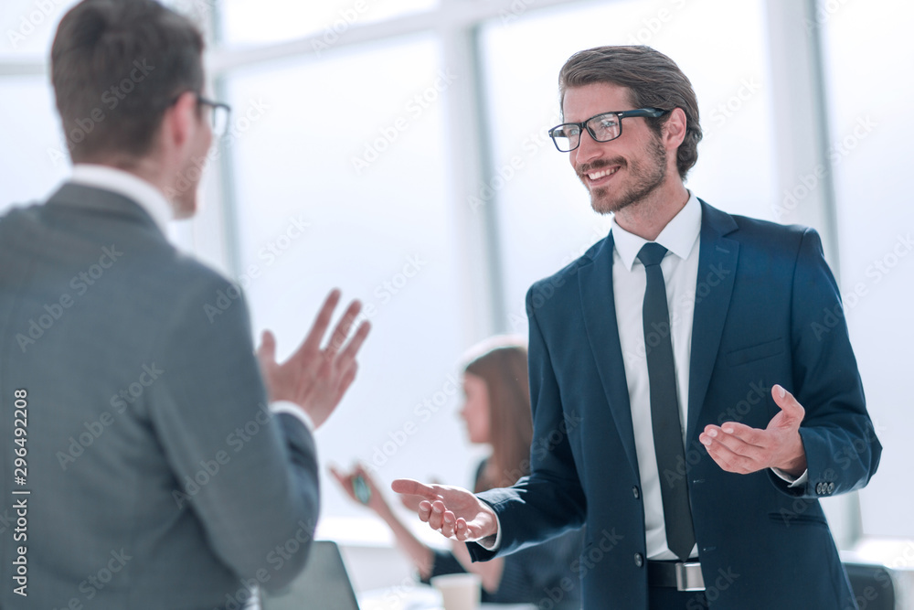 businessman talking with a colleague standing in the office businessman talking with a colleague standing in the office