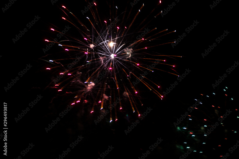 Fireworks in the sky. Salute exploded in a colorful ball in the night sky. Sparks and lights on a black background. Fireworks in the sky. Salute exploded in a colorful ball in the night sky. Sparks and lights on a black background.