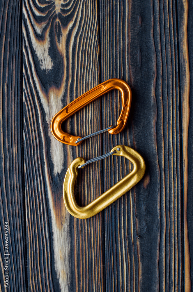 Two objects. Isolated photo of climbing equipment. Parts of carabiners lying on the wooden table Two objects. Isolated photo of climbing equipment. Parts of carabiners lying on the wooden table