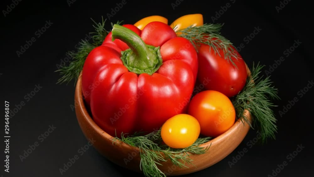 Still life of fresh organic vegetables on wooden plate over black background, close-up. Still life of fresh organic vegetables on wooden plate over black background, close-up.