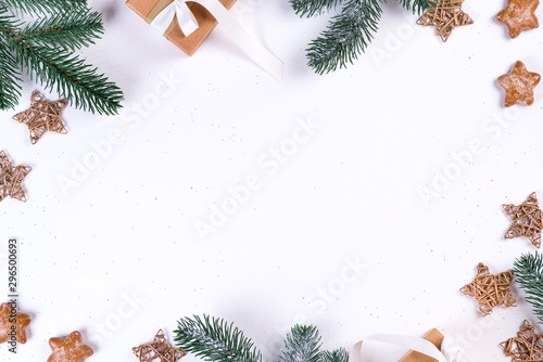 Fir tree branch  gift box and stars on white paper background  top view with copy space
