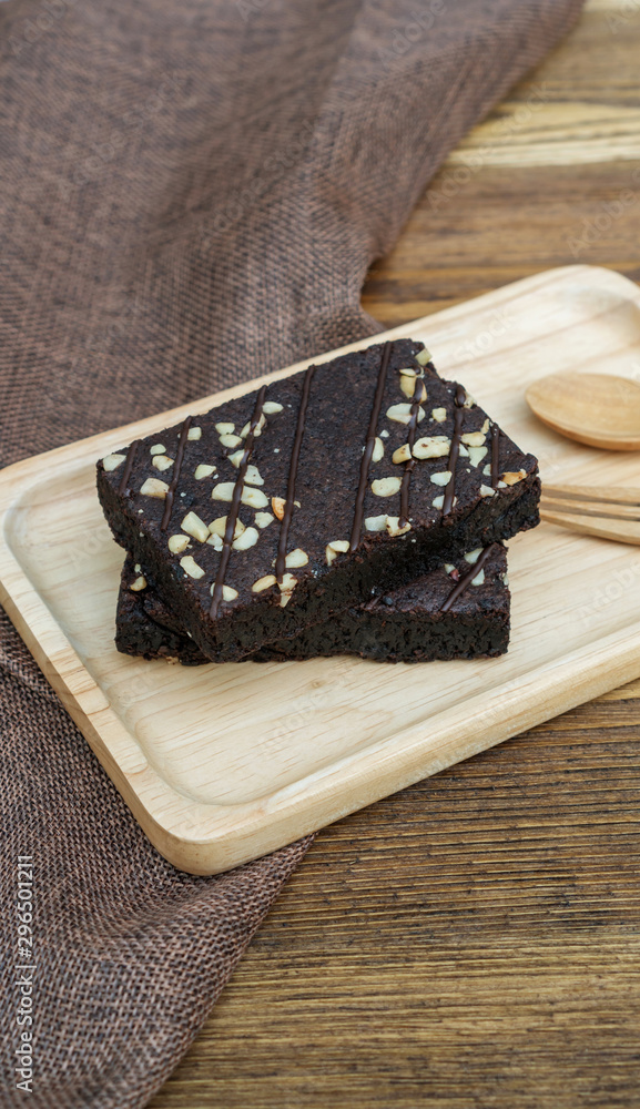 Fototapeta premium Brownies cake, spoon, and fork on a wooden table.