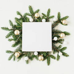 Christmas / New Year composition. Gift box with blank frame copy space, fir branches, Christmas baubles on white background. Flat lay, top view festive holiday mockup.
