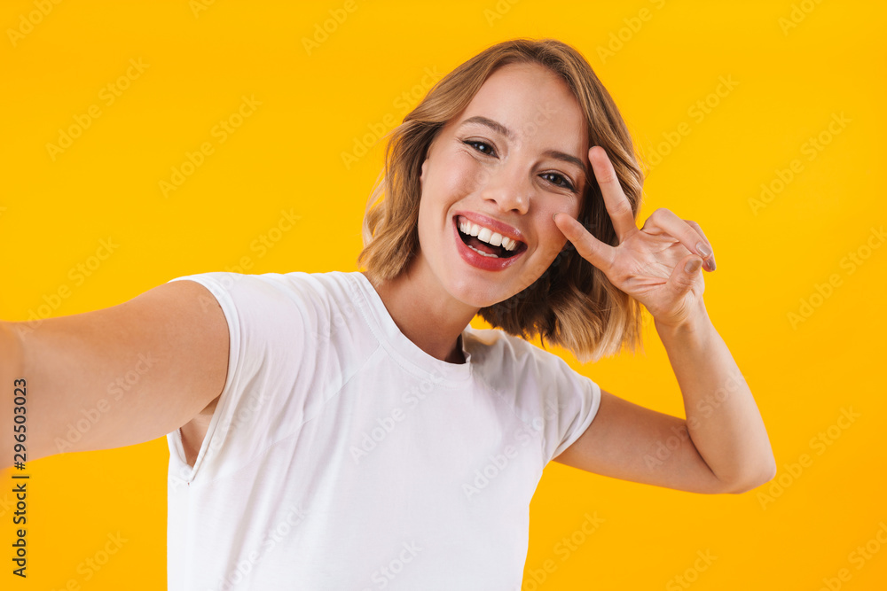 Image of blond woman showing peace fingers and taking selfie photo Image of blond woman showing peace fingers and taking selfie photo