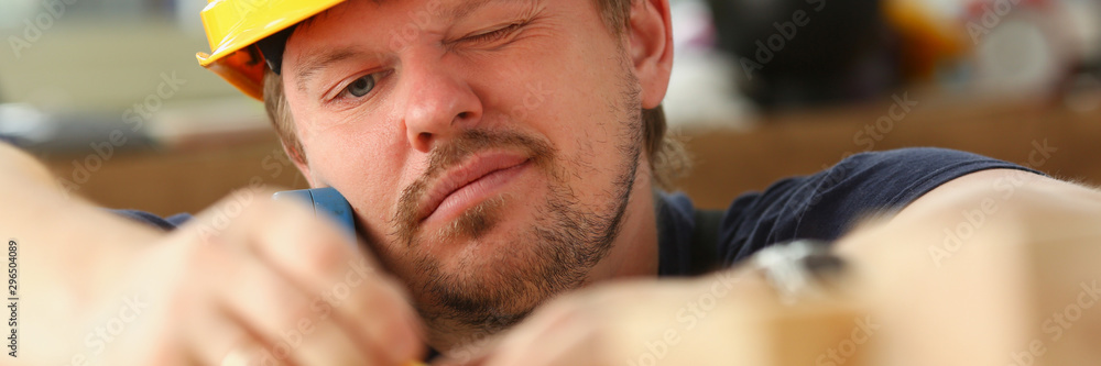 Fototapeta premium Arms of worker measuring wooden bar