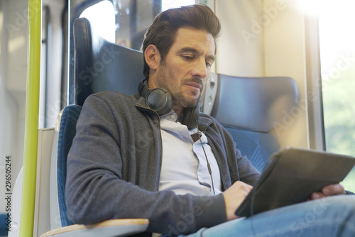 young man watching a movie on a tablet in a train