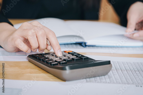 Businesswoman working in the office with calculator for financial data analyzing counting. Business financial analysis and strategy concept.