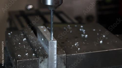 Drill press lowering and peck drilling into piece of aluminum side angle