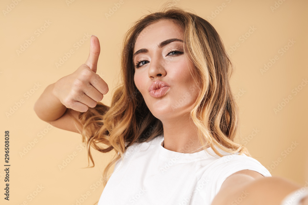 Portrait of alluring woman showing thumb up while taking selfie photo Portrait of alluring woman showing thumb up while taking selfie photo