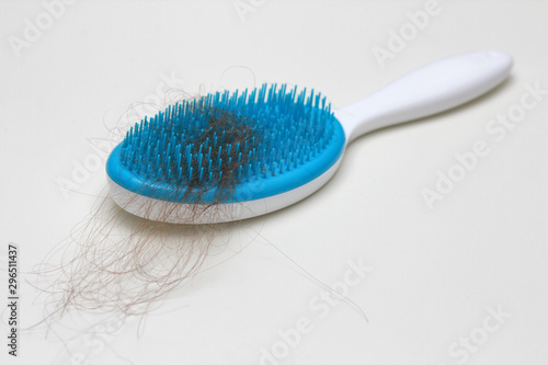 Comb with a lot of hair loss. Health problems. Alopecia. Thin and weak hair. White solid background.