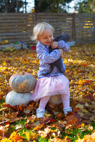 cute blond 3 year old girl is holding her little kitten