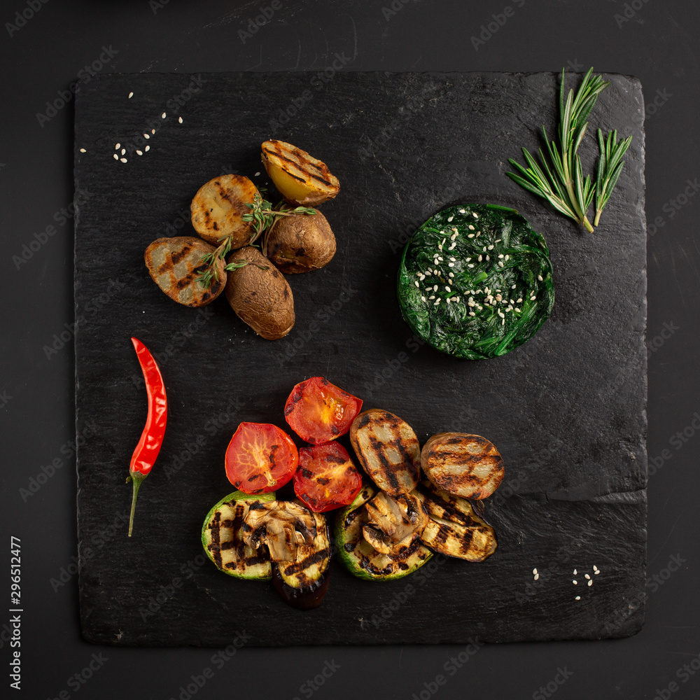 chuka salad and baked vegetables on a black board chuka salad and baked vegetables on a black board