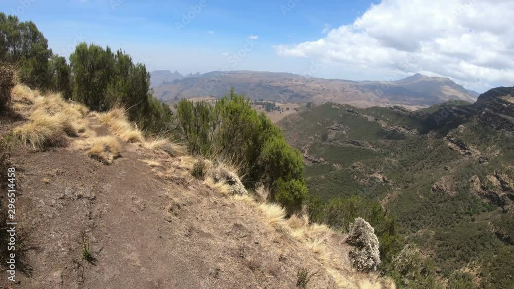 Hiker walking along the edge in the top of Simien mountains trail, First person point of View. Semien Mountain, Ethiopia wilderness, Africa Hiker walking along the edge in the top of Simien mountains trail, First person point of View. Semien Mountain, Ethiopia wilderness, Africa