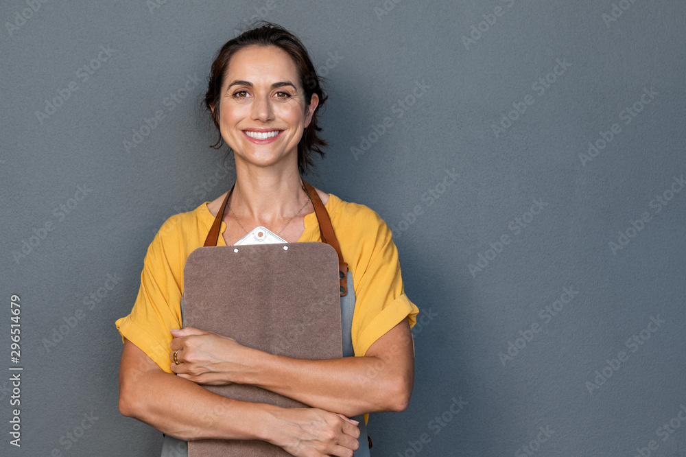 Woman entrepreneur in apron looking at camera - obrazy, fototapety, plakaty 