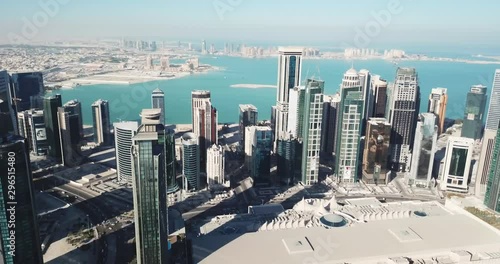 Aerial moving-forward view of futuristic global city in the desert, with high buildings and towers, near the sea, Doha, Qatar photo