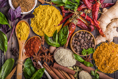 Fototapeta Naklejka Na Ścianę i Meble -  Heaps of various ground spices on wooden background. Georgian spices, Indian spices, Arabian spices. Spice variety. Herbs and spices