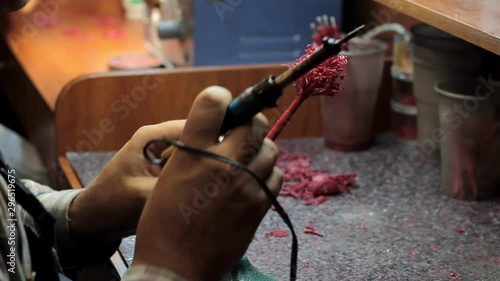 Close-up of a master jeweler surfacing wax blanks of jewelry on a tree before laying in a flask, selective focus