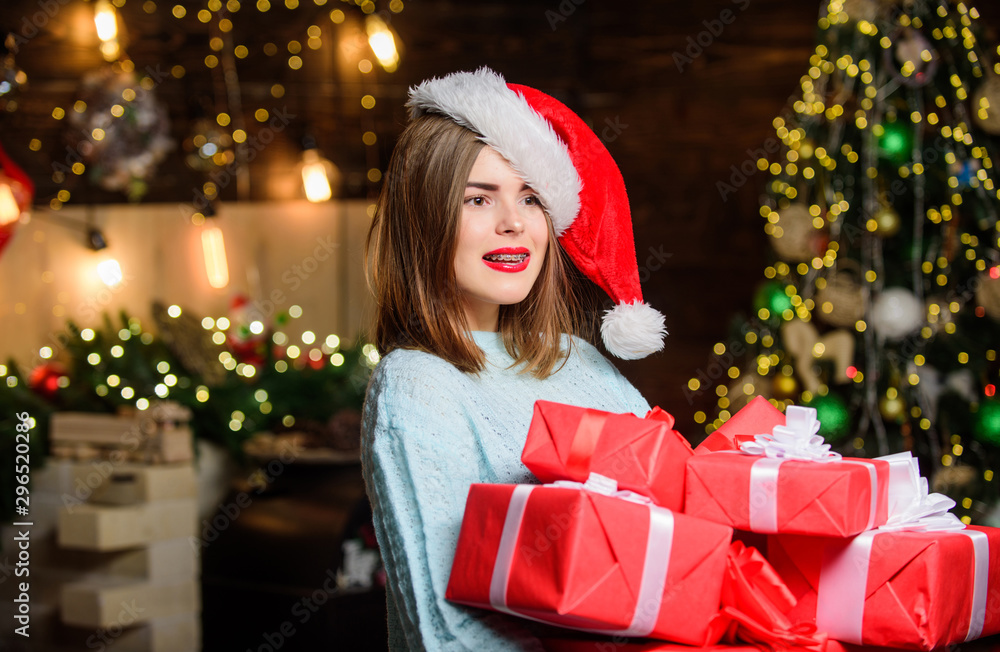 Lady santa celebrate christmas at home. Woman santa claus hat on christmas eve. Girl stylish makeup red lips hold many christmas gifts. Bring magic into someone elses life. Cozy christmas atmosphere Lady santa celebrate christmas at home. Woman santa claus hat on christmas eve. Girl stylish makeup red lips hold many christmas gifts. Bring magic into someone elses life. Cozy christmas atmosphere