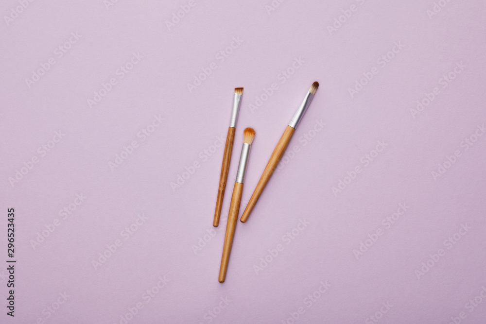 top view of makeup brushes isolated on violet top view of makeup brushes isolated on violet