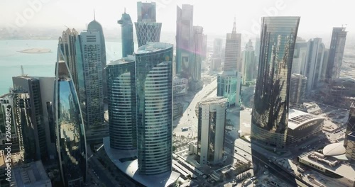 Aerial forward flying view of a futuristic global city with high buildings and towers, developped capital with big avenues, Doha West Bay, Qatar photo