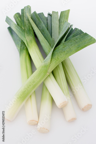 Bunch of fresh full leeks in a white background. Green and white leeks.