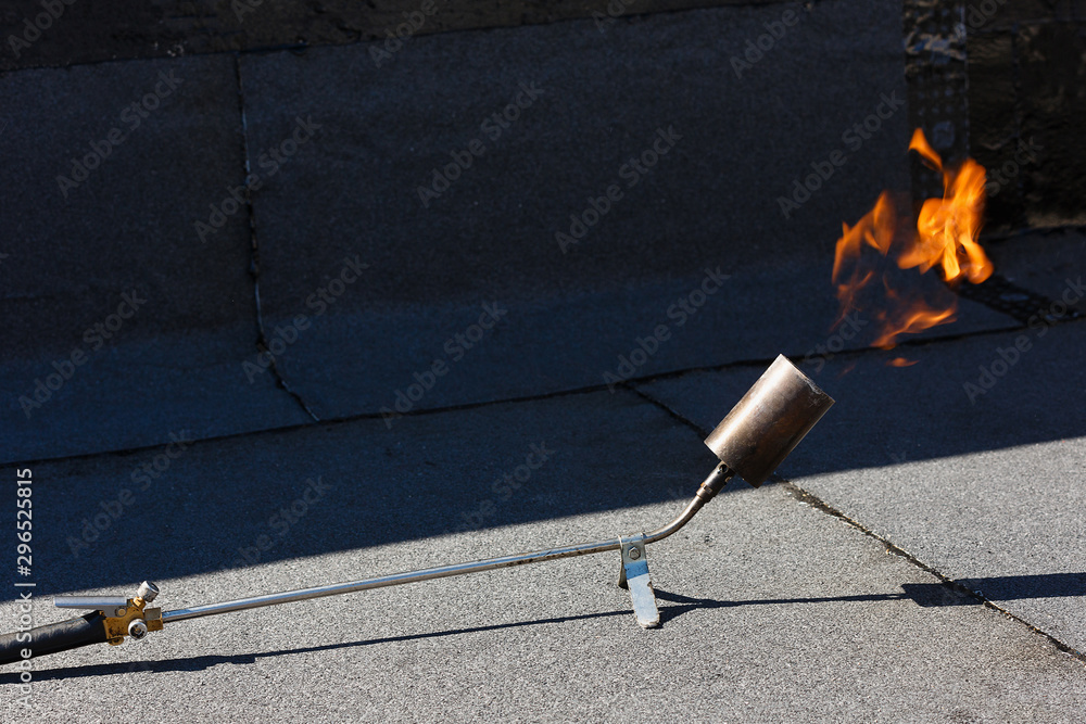 Laying waterproofing by heating roofing felt with fire. Stock Photo | Adobe  Stock
