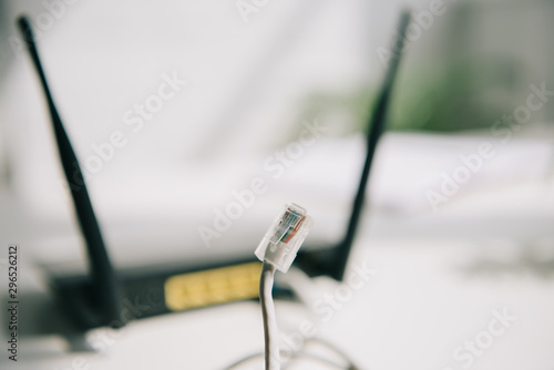 selective focus of wire with connector near black router on white table