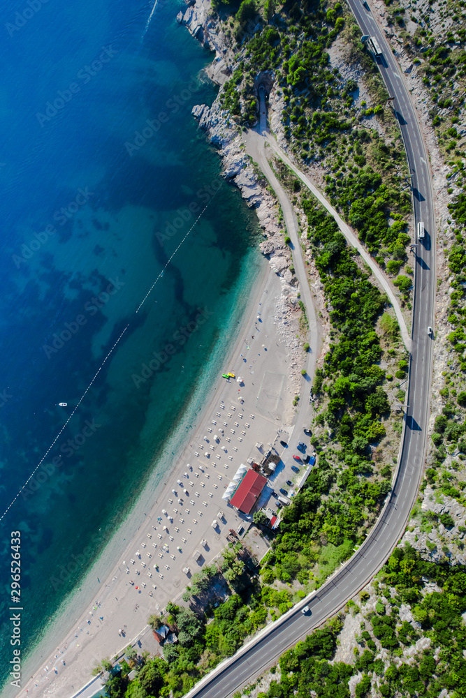Beach by the sea and the road. landscape below (aerial photo from a paraglider) with the coast and the blue sea, Montenegro