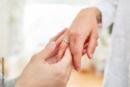 Male hand puts a ring on finger