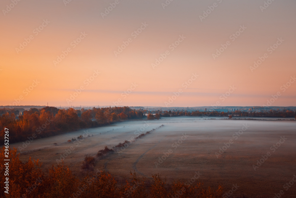Scenic autumn landscape at sunrise. Aerial view on countryside. Colorful autumn background. Soft focus