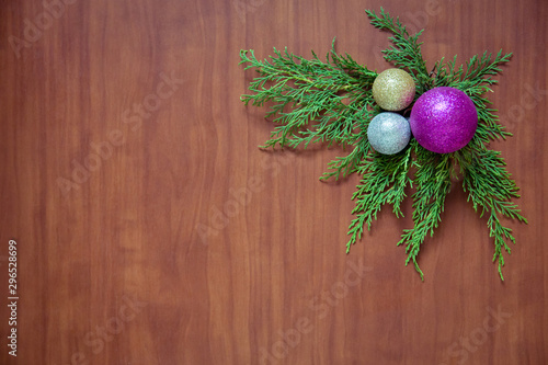 Christmas wooden background with fir branches and balls. New Year's decoration.
