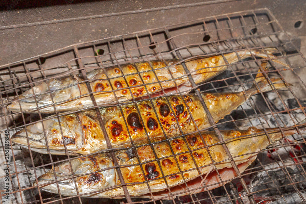 Grilled smoked Golden mackerel fish outside late at night