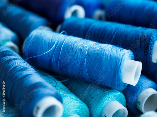 Lots of bobbins of thread for sewing. Threads of blue shade.