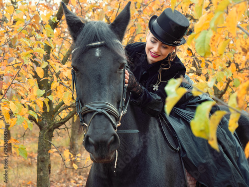 girl in a black dress riding a black horse