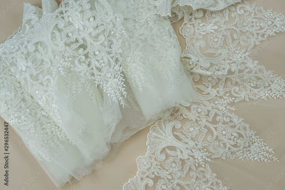 Texture lace fabric. lace on white background studio. thin fabric made of yarn or thread. a background image of ivory-colored lace cloth. White lace on beige background. Texture lace fabric. lace on white background studio. thin fabric made of yarn or thread. a background image of ivory-colored lace cloth. White lace on beige background.