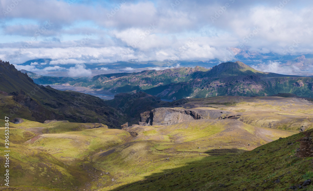 Panoramic breathtaking view on Landscape of Godland and thorsmork with rugged green moss covered rocks and hills, bending river canyon, Iceland, Fimmvorduhals hiking trail. Summer cloudy day.