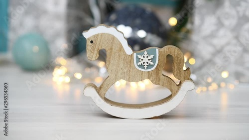 Christmas and New Year background. Wooden horse in vintage style on shining garlands background. Silver colors. Festive mood. Christmas tree toys and gifts. Great for New Year and Christmas card