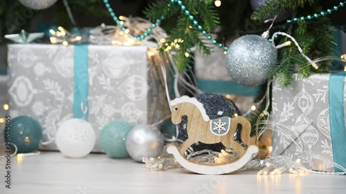 Christmas and New Year background. Wooden horse in vintage style on shining garlands background. Silver colors. Festive mood. Christmas tree toys and gifts. Great for New Year and Christmas card