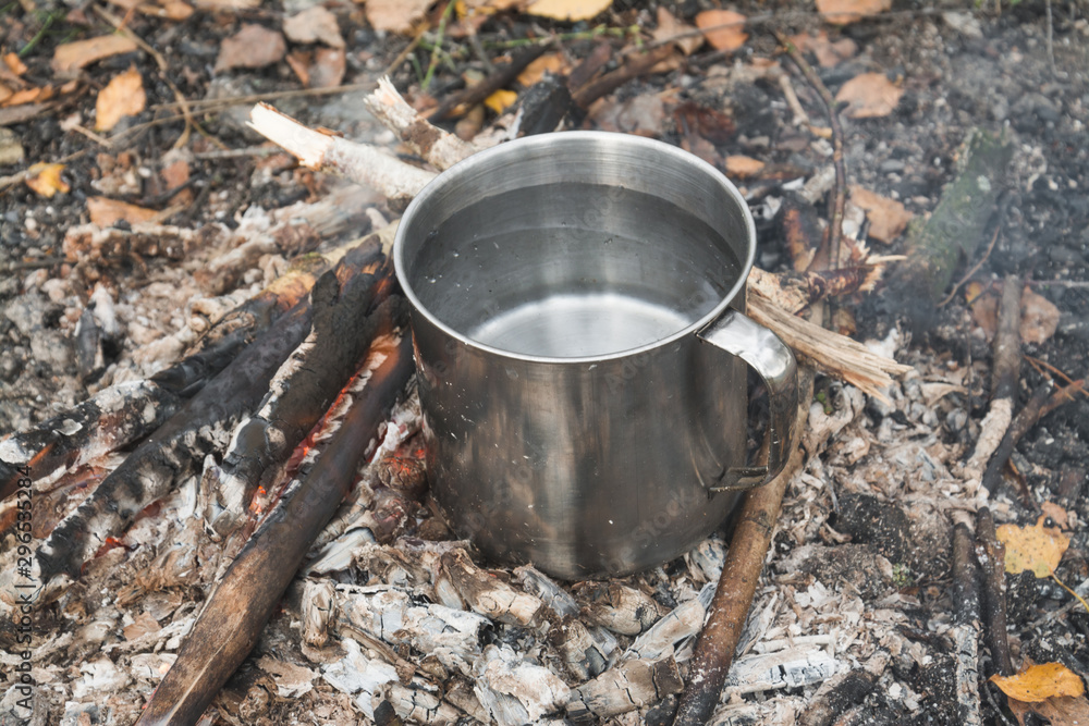 Travel titanium cup on wood on forest background