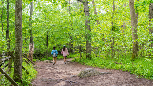 Mother and teen daughter walking down path