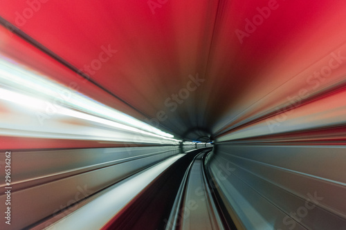 High speed curved motion to the right inside a tunnel with red light.